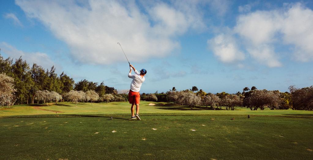 a man swinging a golf club on a golf course.