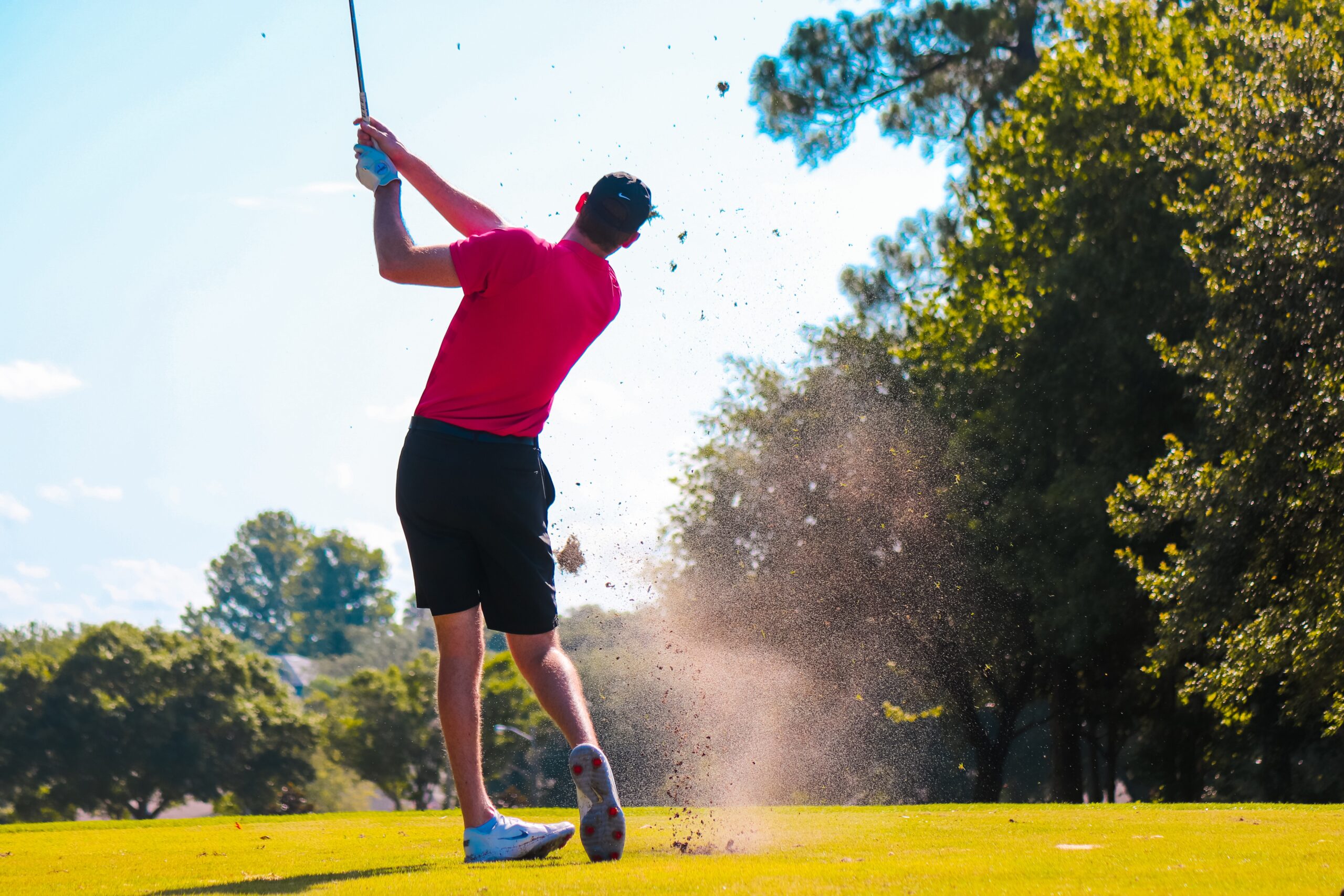 a man hitting a golf ball with a golf club.